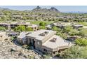 Scenic aerial view of a luxury home in a golf community with mountain views at 10222 E Southwind Ln # 1018, Scottsdale, AZ 85262