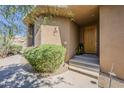 Inviting front entrance with a wood door, desert landscaping, and a serene atmosphere at 10222 E Southwind Ln # 1018, Scottsdale, AZ 85262