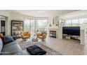 Spacious living room with large windows, cozy seating, and a fireplace at 10222 E Southwind Ln # 1018, Scottsdale, AZ 85262