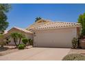 Beige single-story home with a two car garage and desert landscaping at 10845 W Manzanita Dr, Peoria, AZ 85345