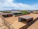 An aerial view highlighting the backyard with storage sheds and the property's perimeter fencing at 15438 E Milton Dr, Scottsdale, AZ 85262