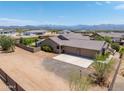 Aerial view showcasing a home with a 3-car garage, extra parking, and desert landscaping at 15438 E Milton Dr, Scottsdale, AZ 85262