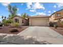 Tan home with a two car garage, desert landscaping, concrete driveway, and tile roof at 15910 W Fillmore St, Goodyear, AZ 85338