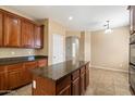 Spacious kitchen with an island, granite countertops, and wood cabinets at 15910 W Fillmore St, Goodyear, AZ 85338