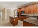 Kitchen featuring dark wood cabinets, granite countertops, and modern appliances at 15910 W Fillmore St, Goodyear, AZ 85338
