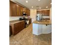 A kitchen features granite countertops, a kitchen island, and stainless steel appliances at 16559 W Lincoln St, Goodyear, AZ 85338