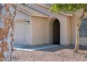 Close-up of the front entrance with an arched entryway, stucco facade, and a two car garage at 1718 E Harwell Rd, Phoenix, AZ 85042