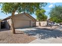 Suburban home featuring desert landscaping, a spacious driveway, and an attached two-car garage at 1718 E Harwell Rd, Phoenix, AZ 85042