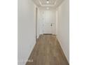 Bright hallway with white walls and sleek tile flooring leads to a welcoming interior at 19028 W Rose Ln, Waddell, AZ 85355