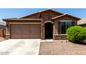 Close-up of the front facade featuring stone accents around the arched entry and a well-manicured shrub at 2176 W Larissa Ln, San Tan Valley, AZ 85144