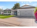 Classic home exterior with a spacious driveway, blue door, manicured lawn, and an attached garage with updated features at 2316 N 81St St, Scottsdale, AZ 85257