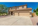Beautiful tan two-story home, stone accents, three-car garage and desert landscaping at 26272 N 73Rd Dr, Peoria, AZ 85383