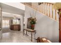 Bright foyer featuring tile floors, a staircase, and an elegant console table at 26272 N 73Rd Dr, Peoria, AZ 85383