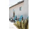 Blue Adirondack chairs sit in front of a textured stucco wall in the home's courtyard at 2630 E Lovebird Ln, Gilbert, AZ 85297