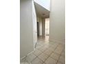 Neutral tiled hallway view leading toward an open floorplan with natural light at 29906 W Whitton Ave, Buckeye, AZ 85396