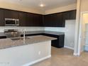 Modern kitchen with granite countertops, stainless steel appliances, and dark wood cabinets at 31774 N Bandit Rd, San Tan Valley, AZ 85143