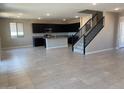 Open-concept living area with tile flooring connecting the kitchen and staircase at 31774 N Bandit Rd, San Tan Valley, AZ 85143