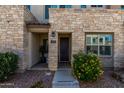 Inviting townhome entrance with a stone facade, well-maintained landscaping, and a clearly marked unit number at 4548 S Renaissance Dr # 103, Gilbert, AZ 85297