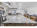 Bright kitchen featuring a large island with seating and stylish granite countertops at 4822 N 63Rd Ln, Phoenix, AZ 85033