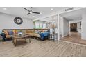 Inviting living room featuring hardwood floors, a ceiling fan, and a comfortable sofa at 4822 N 63Rd Ln, Phoenix, AZ 85033