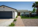 Charming single-story home featuring a landscaped front yard, brick walkway, and a spacious two-car garage at 6907 E Palm Ln, Scottsdale, AZ 85257