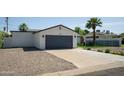 Single-story home featuring a two-car garage, desert landscaping, and a well-maintained lawn at 6907 E Palm Ln, Scottsdale, AZ 85257