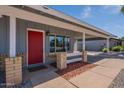 Inviting entryway with a striking red front door and covered porch, enhancing curb appeal at 719 W Pampa Ave, Mesa, AZ 85210