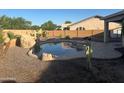 Backyard pool featuring rock waterfall and desert landscaping for a relaxing oasis at 7327 W Donner Dr, Laveen, AZ 85339