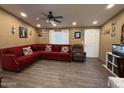 Cozy living room featuring wood-look floors, a comfortable red couch and a lighted ceiling fan at 8218 S 7Th St # Ofc, Phoenix, AZ 85042
