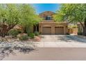 Charming two-story home showcasing a well-manicured lawn and a spacious three-car garage at 8447 W Tether Trl, Peoria, AZ 85383