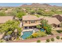 Stunning aerial view of the backyard featuring a private pool, covered patio, and lush landscaping at 8447 W Tether Trl, Peoria, AZ 85383