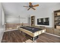 Spacious game room with a pool table, ceiling fan, and built-in shelving, perfect for entertaining guests at 8758 W Hayward Ave, Glendale, AZ 85305