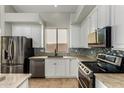 Modern kitchen with stainless steel appliances, white cabinets, stylish backsplash, and ample counter space at 8758 W Hayward Ave, Glendale, AZ 85305