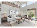 Bright, contemporary living room featuring soaring ceilings, a large white sofa, and access to the backyard at 8758 W Hayward Ave, Glendale, AZ 85305