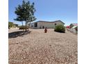 View of the rear of the home with desert landscaping and mature trees for shade at 8840 E Sunland Ave # 142, Mesa, AZ 85208