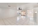 Bright living room with white tile flooring, a ceiling fan, and sliding glass door to patio at 8884 E Arizona Park Pl, Scottsdale, AZ 85260