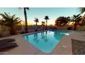 Backyard pool with palm trees and lounge chairs create a relaxing outdoor oasis for entertaining at 10794 S Coolwater Dr, Goodyear, AZ 85338