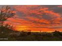 Panoramic sunset view over a community of homes, featuring vibrant colors and lush greenery at 10794 S Coolwater Dr, Goodyear, AZ 85338