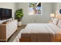 Well-lit bedroom with a window view, dresser, and light-colored walls at 1105 W Anderson Dr, Phoenix, AZ 85023