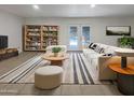 Bright living room featuring stylish decor, a bookshelf, and sliding glass doors to the backyard at 1105 W Anderson Dr, Phoenix, AZ 85023