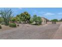 Desert home exterior with mature trees, a circular driveway, and well-maintained landscaping at 12682 N 80Th Pl, Scottsdale, AZ 85260