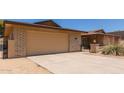 Attached two-car garage with driveway, complemented by desert landscaping and a gated front courtyard at 132 W Wood Dr, Phoenix, AZ 85029