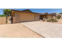 Attached two-car garage with driveway, complemented by desert landscaping and a gated front courtyard at 132 W Wood Dr, Phoenix, AZ 85029