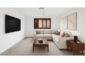 Staged living room with neutral sectional, TV, and stylish decor for a cozy atmosphere at 1417 W Los Arboles Pl, Chandler, AZ 85224