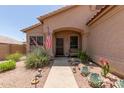 Inviting home entrance with desert landscaping, a stone walkway, and an American flag at 17201 E Hillcrest Dr, Fountain Hills, AZ 85268