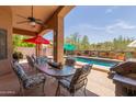 Covered patio with comfortable seating and an outdoor grill, perfect for poolside entertaining at 17201 E Hillcrest Dr, Fountain Hills, AZ 85268