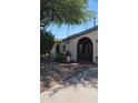 Charming stucco home featuring mature landscaping and an arched entryway with rod iron decor at 1743 W Acoma Dr, Phoenix, AZ 85023