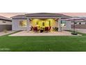 Inviting covered patio with outdoor seating, a grill, and a lush green lawn, perfect for entertaining and relaxing at 17721 W Sandalwood Dr, Goodyear, AZ 85338