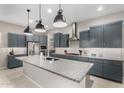 Modern kitchen featuring stainless steel appliances, granite countertops, a spacious island, and stylish pendant lighting at 17721 W Sandalwood Dr, Goodyear, AZ 85338