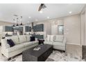Open-concept living area flows into the kitchen, with a neutral color palette, modern lighting, and stylish furniture at 17721 W Sandalwood Dr, Goodyear, AZ 85338